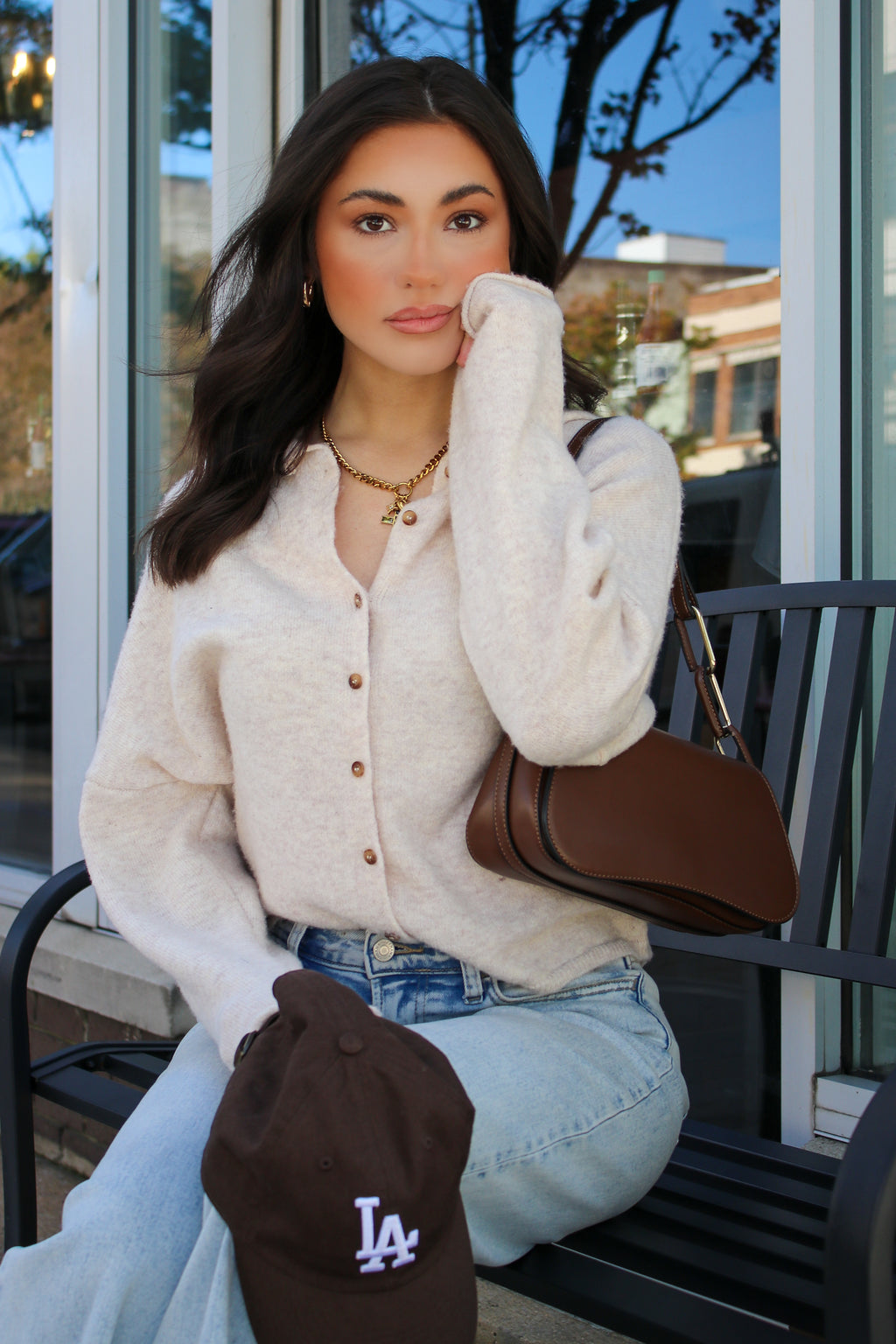 New Classic Button Down Cardigan Sweater in oatmeal, seated with a brown bag