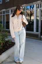 New Classic Button Down Cardigan Sweater in oatmeal, full length outdoors with wide leg jeans